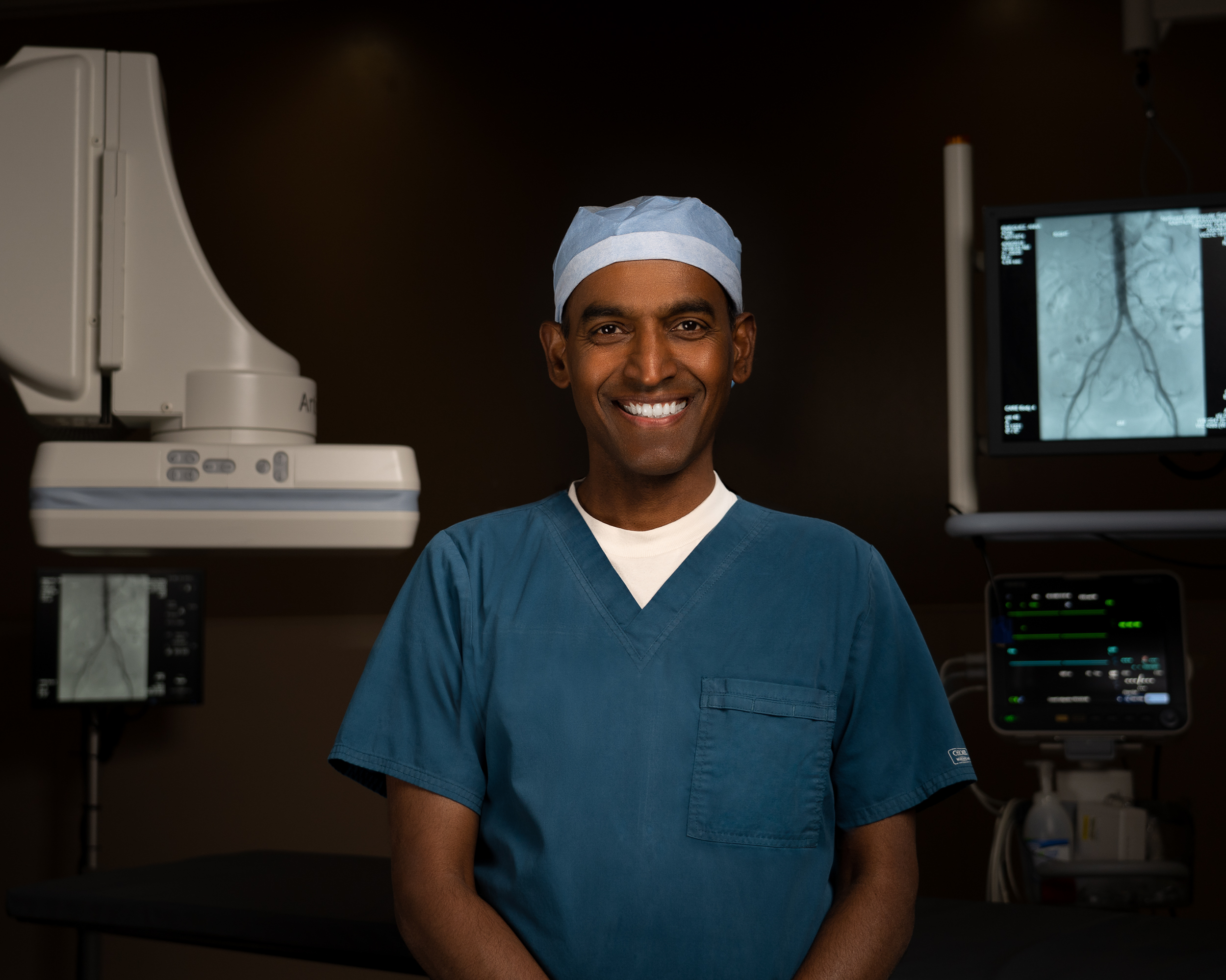 Dr. Kasthuri poses in the room where he conducts advanced, minimally invasive surgeries in an outpatient setting.